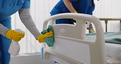 Two Professionals Cleaning Hospital Bed